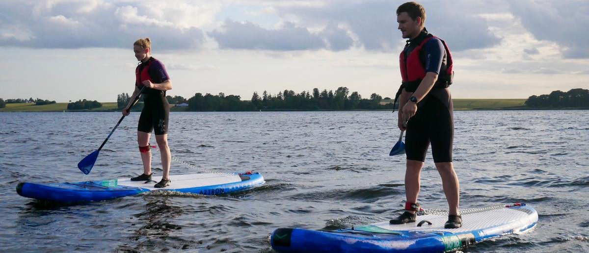 Two people paddle boarding in a lake