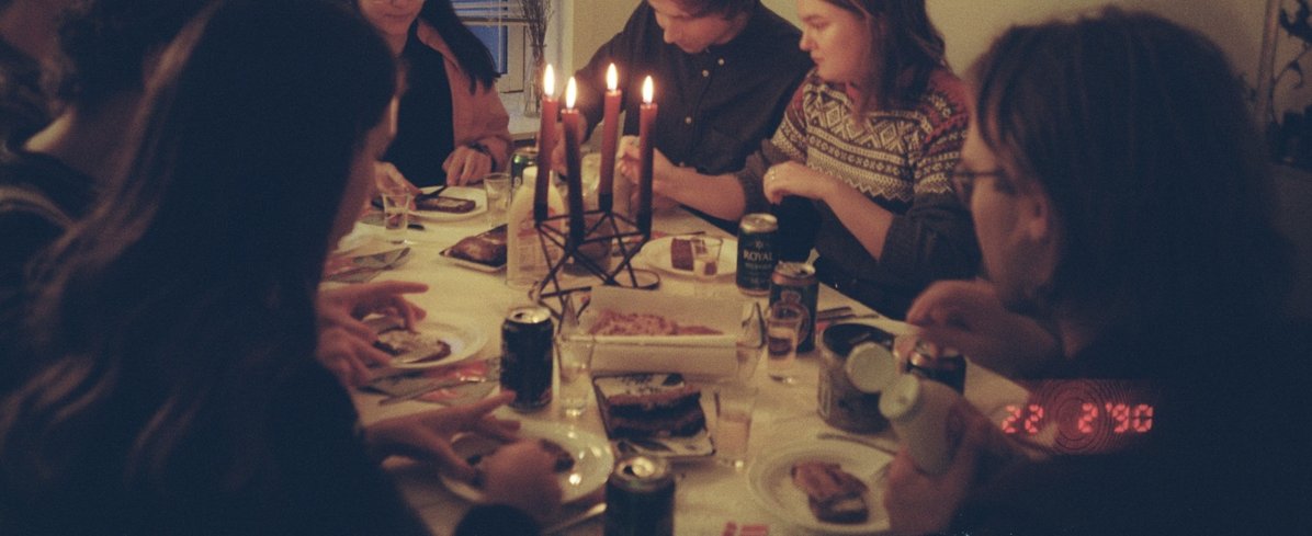 People sitting around table with candles