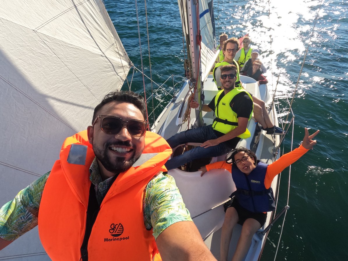 A selfie of 4 people in a sailing boat