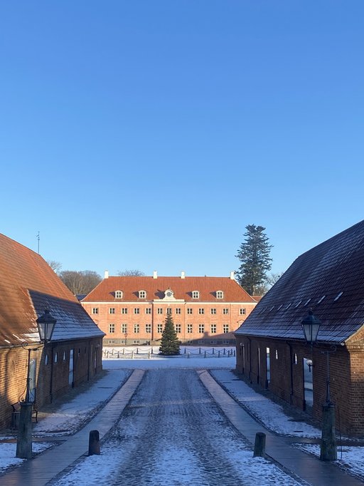 A road covered in snow leading to a bulding