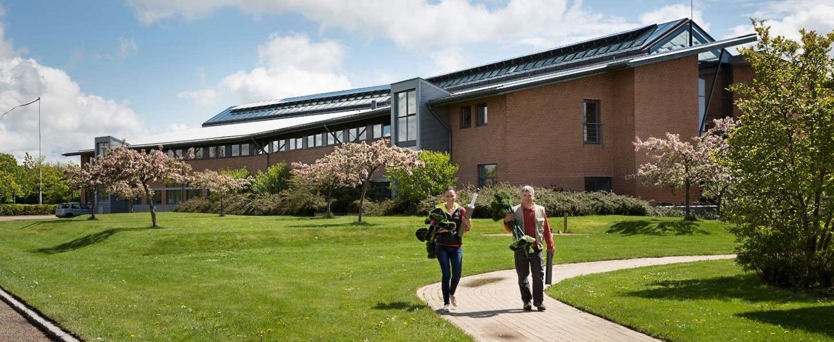 Two people walking in front of the Aarhus University Flakkebjerg building