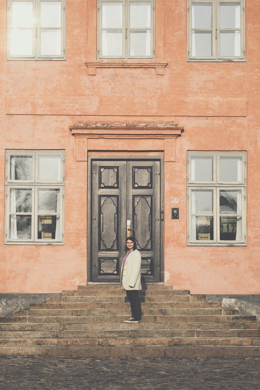 A picture of a girl standing in front of a building