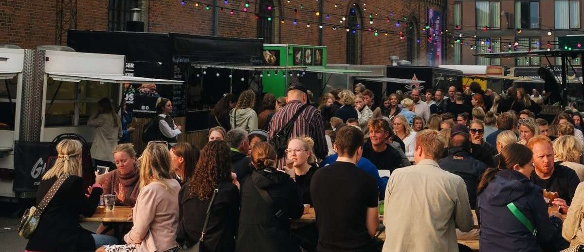 A crow of people sitting on benches eating outside