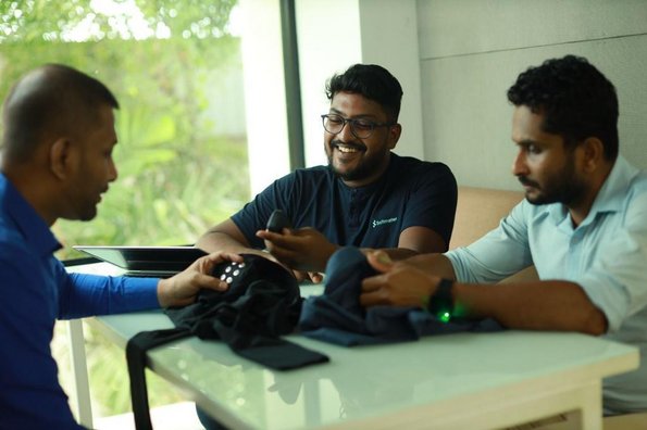 3 men siting around a table, talking