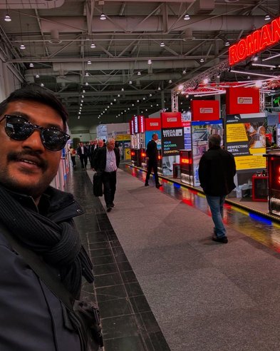 Man taking a selfie wearing sunglasses indoors with displays lining the hallway