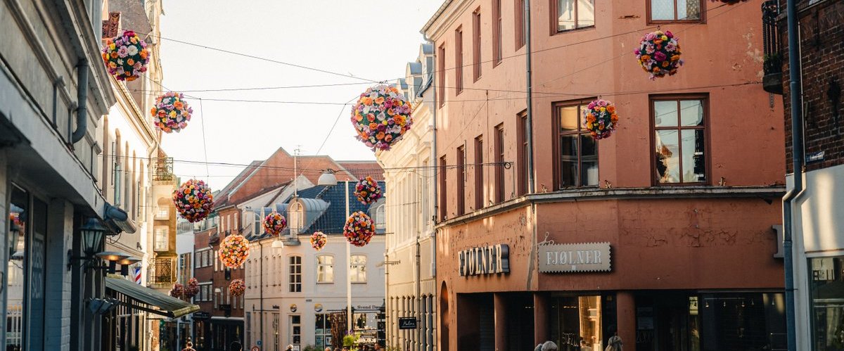 Flower decorations hanging from wires between buildings