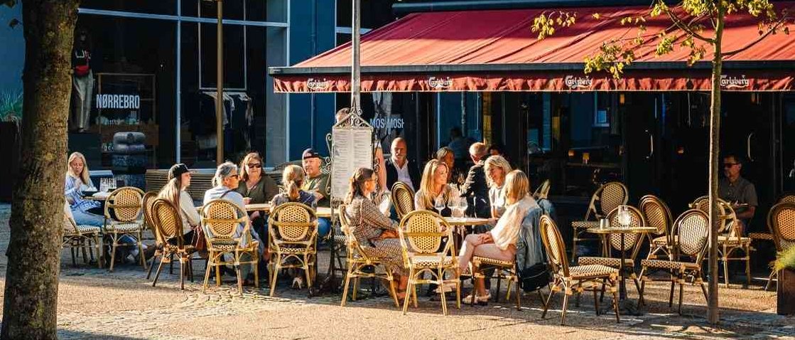 People eating outside a restaurant in the sunshine