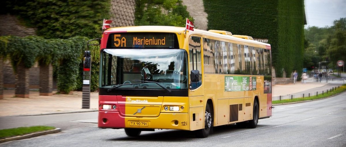 A yellow bus with Danish flags on the sides