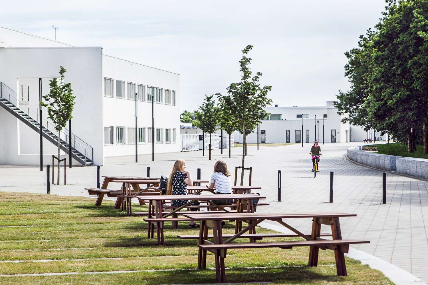 Aarhus University Herning building with people sitting on benches outside